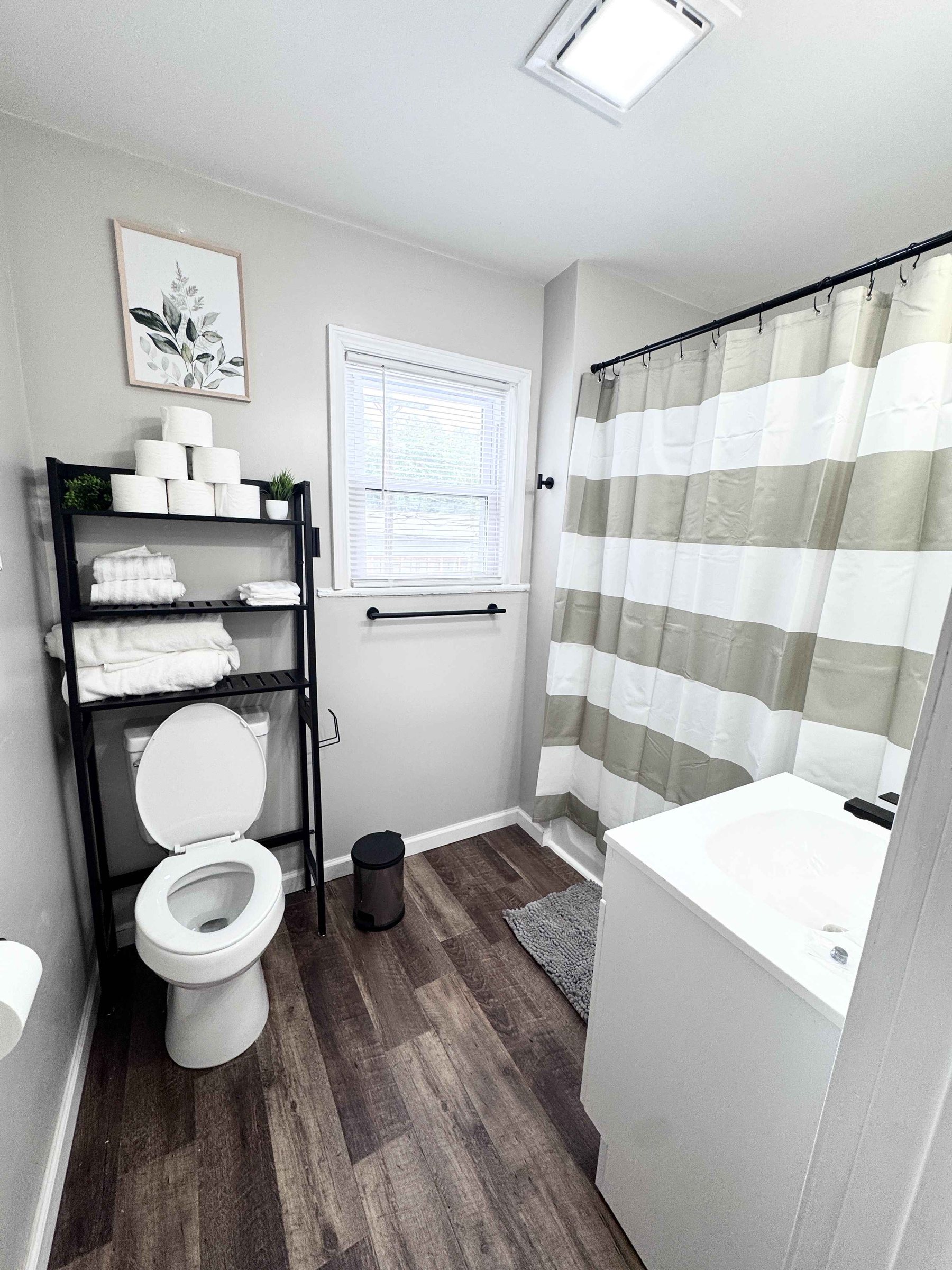 Unit 14 - Bathroom with vanity, stocked towel shelf, and shower