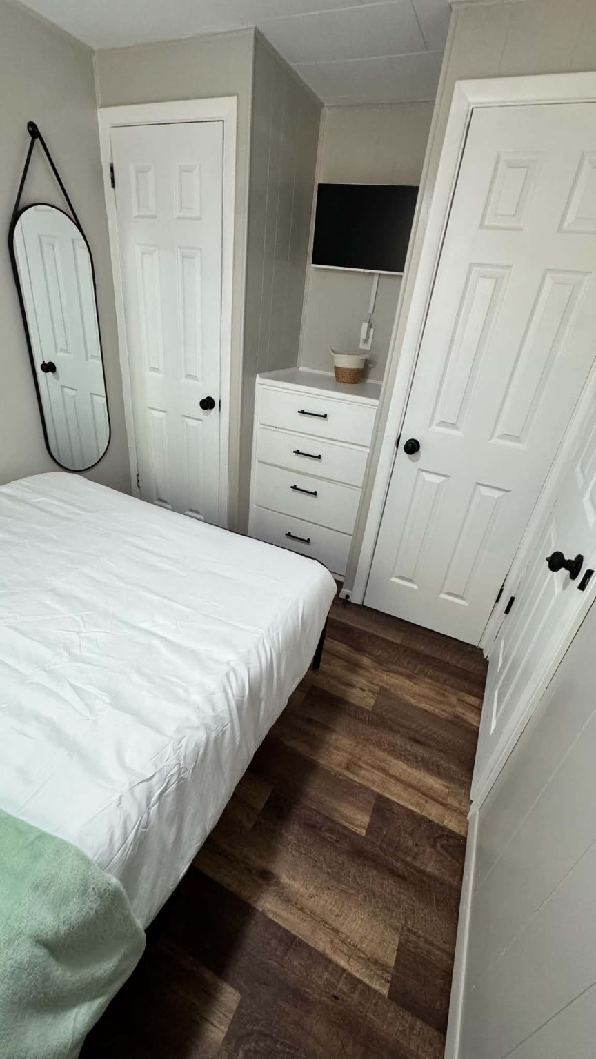 Unit 9 - Bedroom with dresser, TV, and full-length mirror