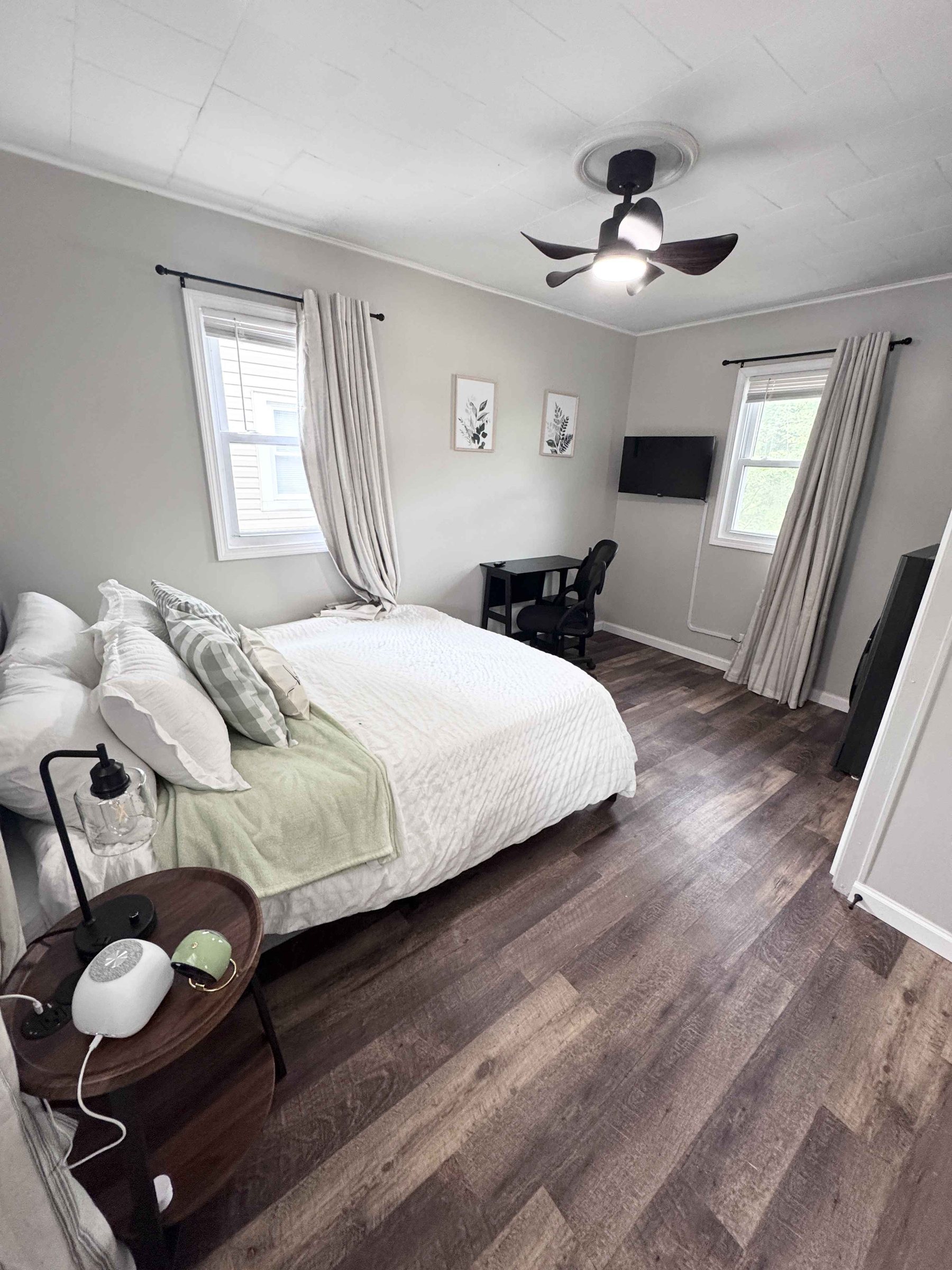 Unit 14 - Bedroom detail with mirror, soft curtains, and neutral decor