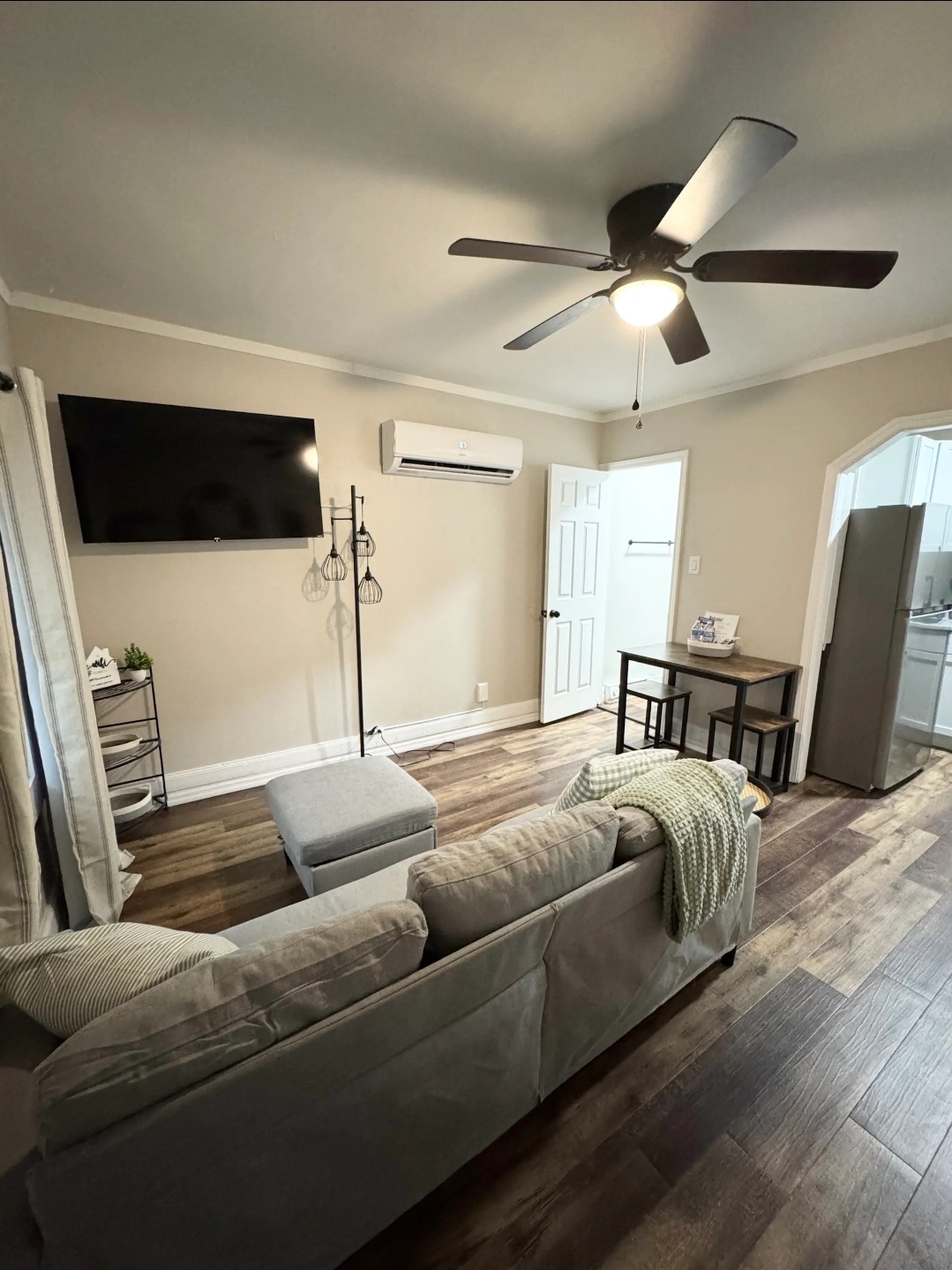 Unit 6 - Spacious living room with sectional sofa, TV, and ceiling fan