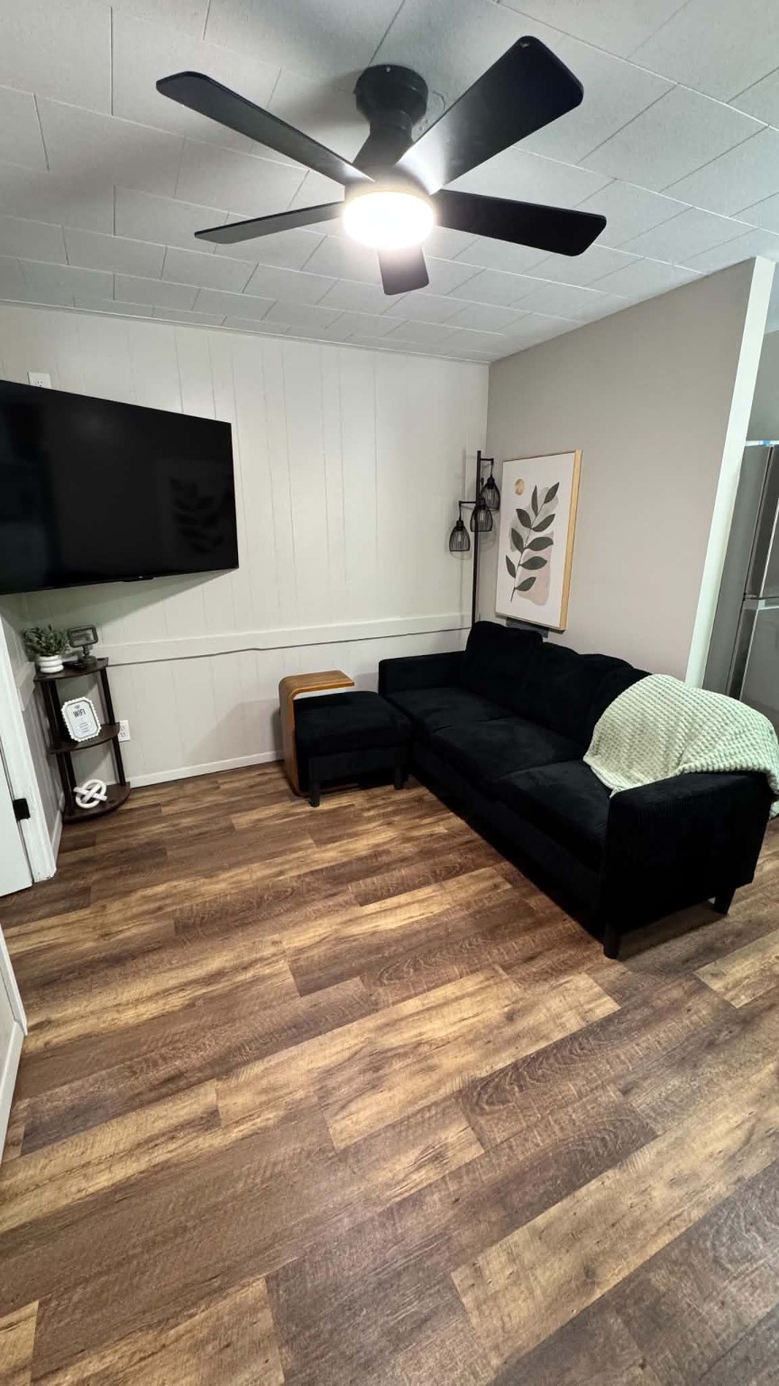 Unit 9 - Living room with sofa, smart TV, and ceiling fan