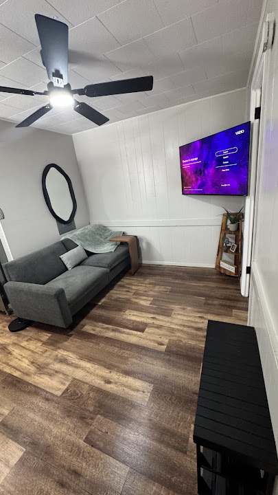 Unit 7 - Sitting area with sofa, smart TV, and ceiling fan